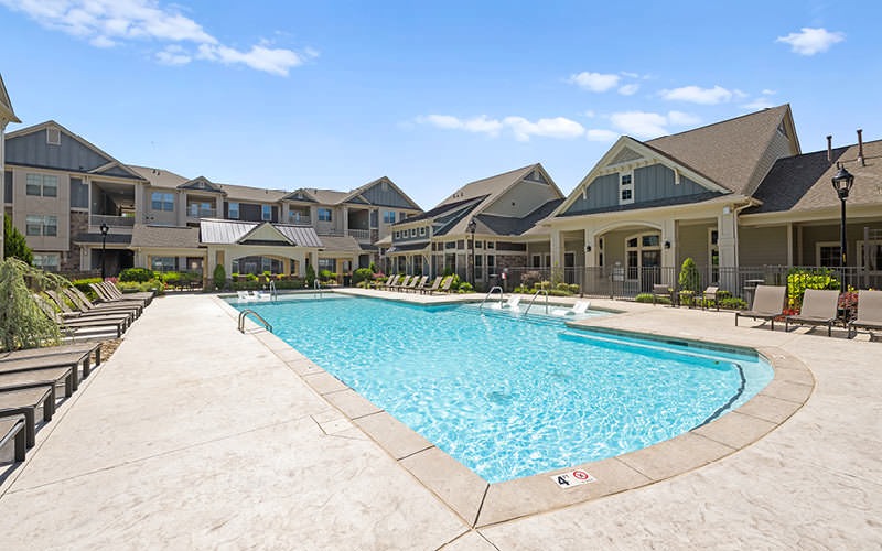 gated swimming pool with lounge chairs