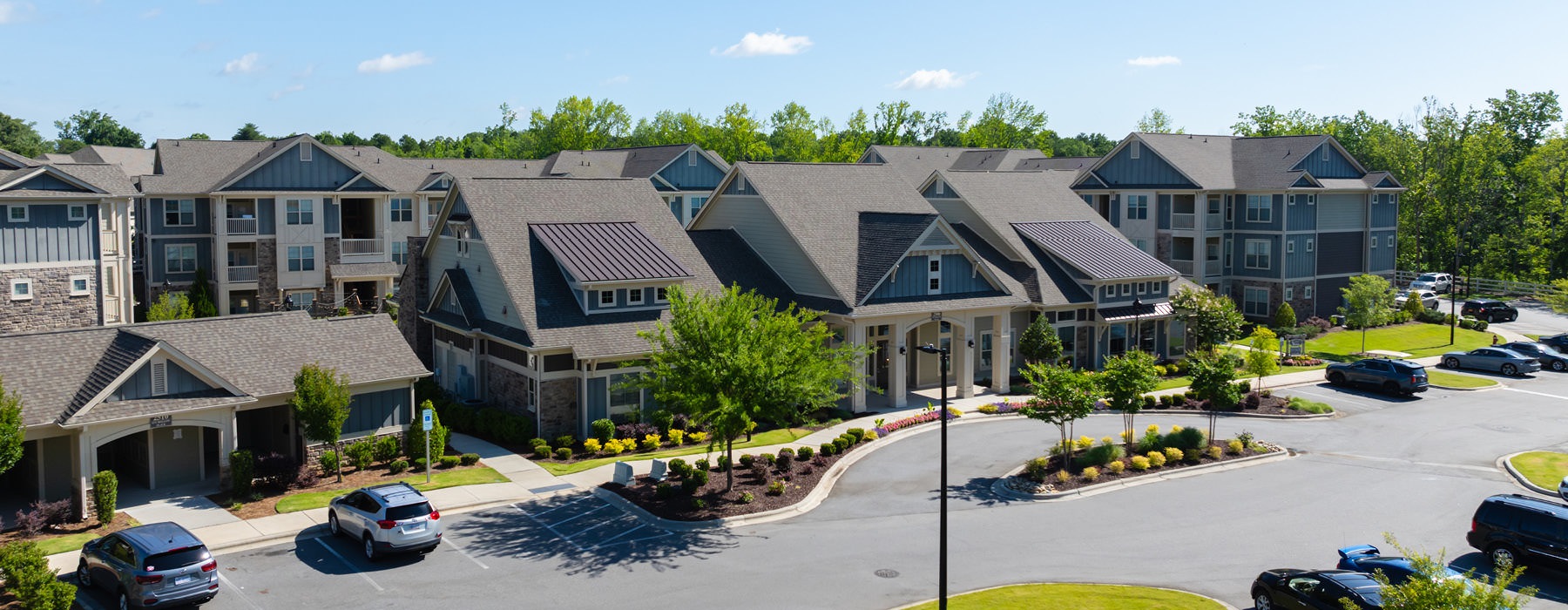 large parking lot  in front of leasing office and apartments
