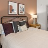 Spacious and well lit bedroom with carpeted floors and a large window 